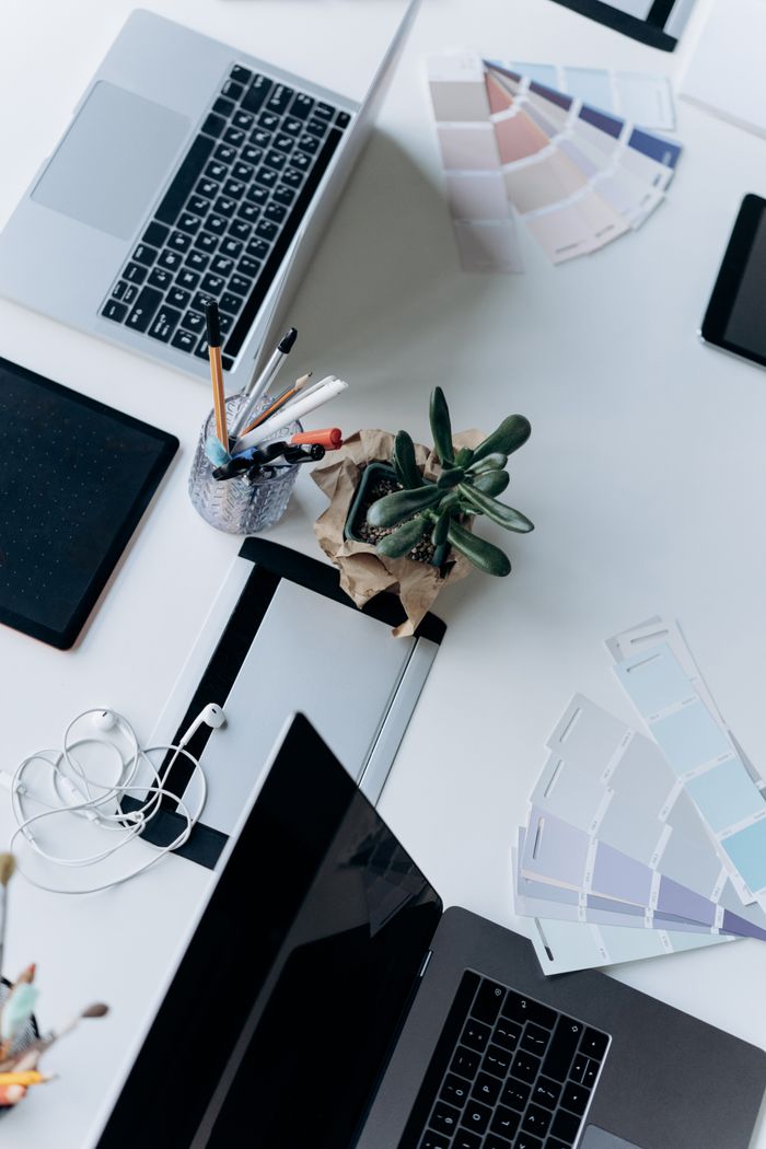 Mastering the First Impression: Your intriguing post title goes here Top view of an organized workspace featuring a laptop, succulent plant, and office supplies on a white desk.